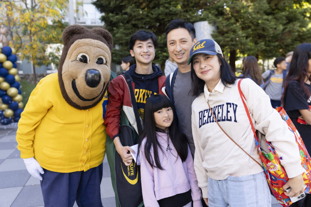 Incoming freshman Isaac Auyeung and his family pose with Oski during the first campus move-in day of fall semester. Isaac and his mother are wearing Berkeley sweatshirts.