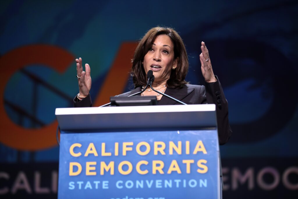 Kamala Harris speaking at a podium at the California Democratic State Convention in 2019