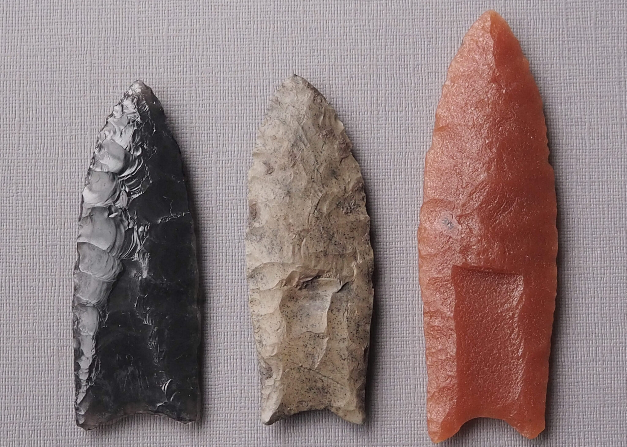 Three replica Clovis points arranged next to each other that show the sharp...