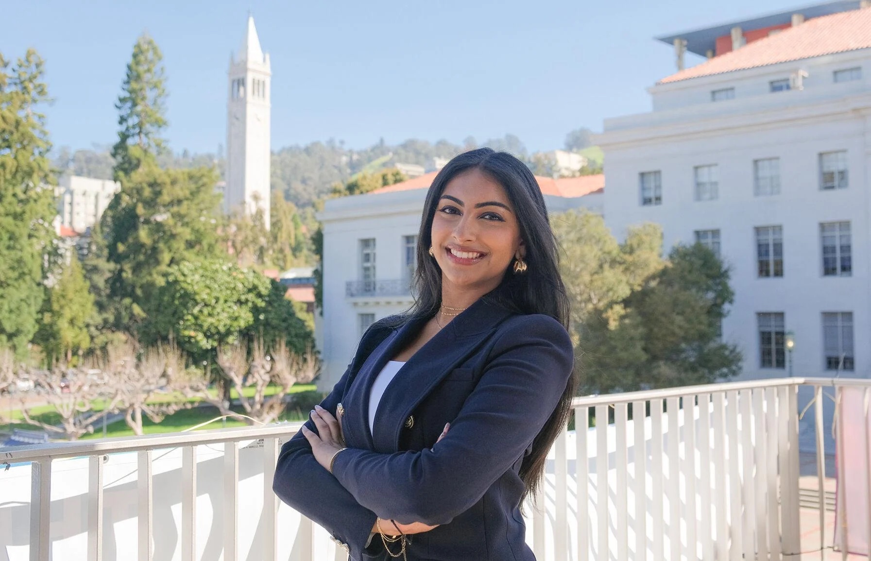 Shrinidhi Gopal stands with arms crossed wearing a blue blazer on campus.