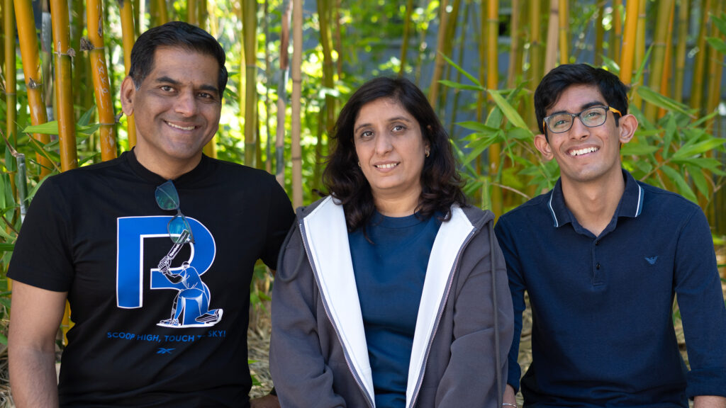 Vihaan sits outside with his mom and dad