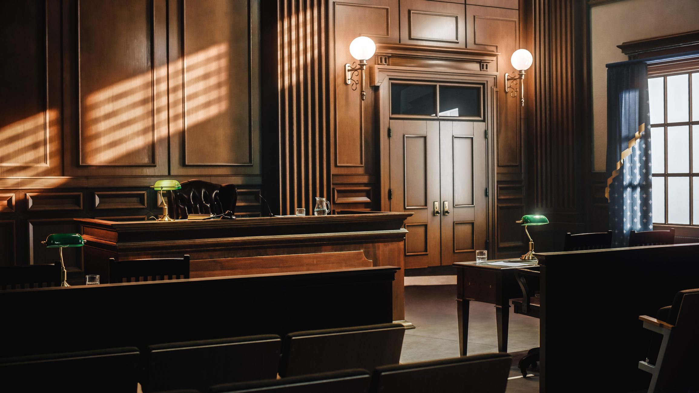 An empty courtroom, with wooden benches and chairs, elegant daylight from windows to the right