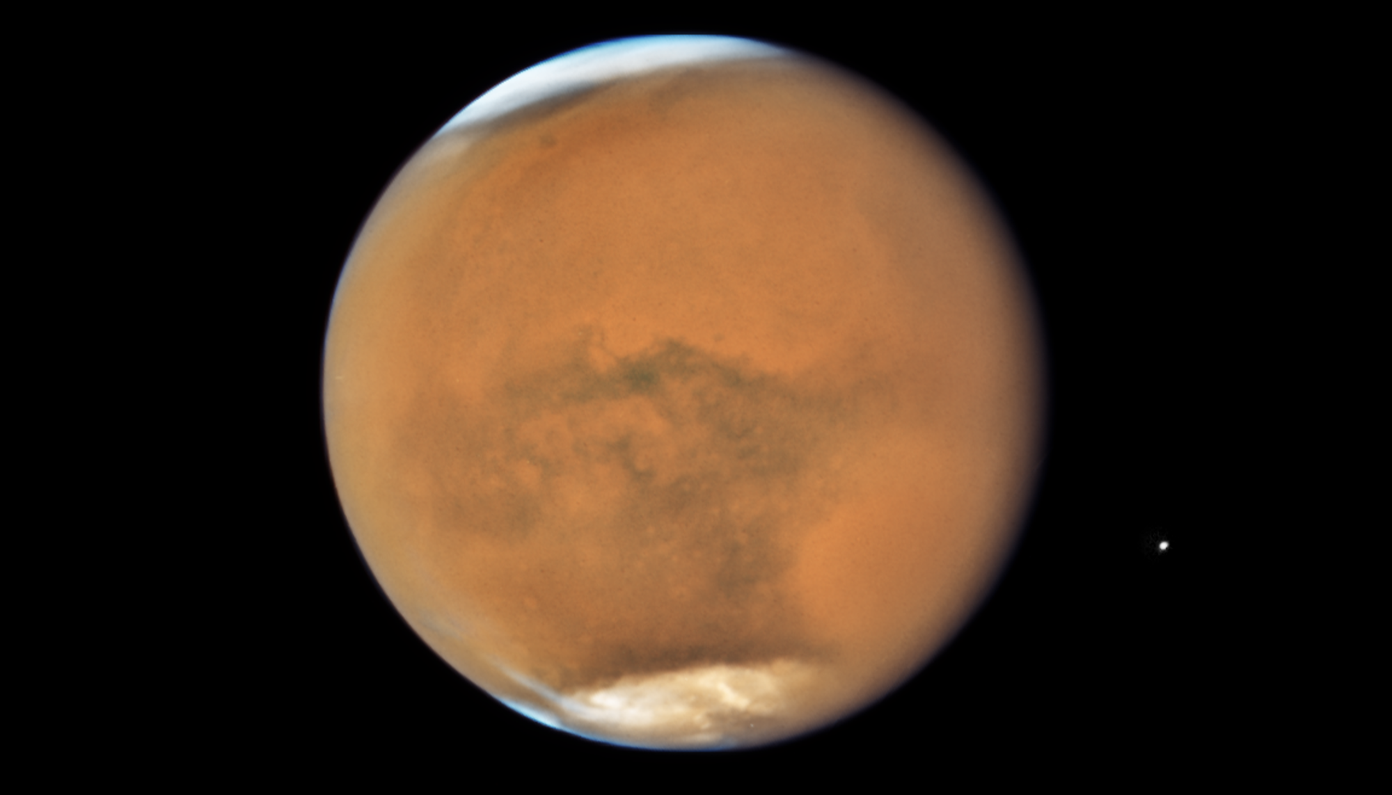 the bridk-red planet Mars with white caps at poles