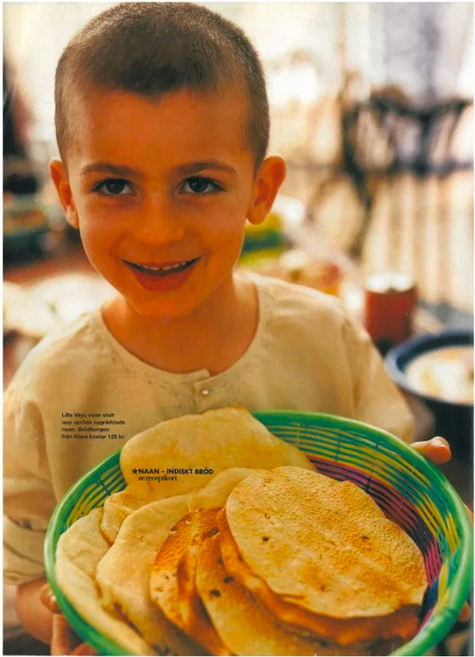 a young boy smiling at the camera and holding a green bowl filled with flatbreads