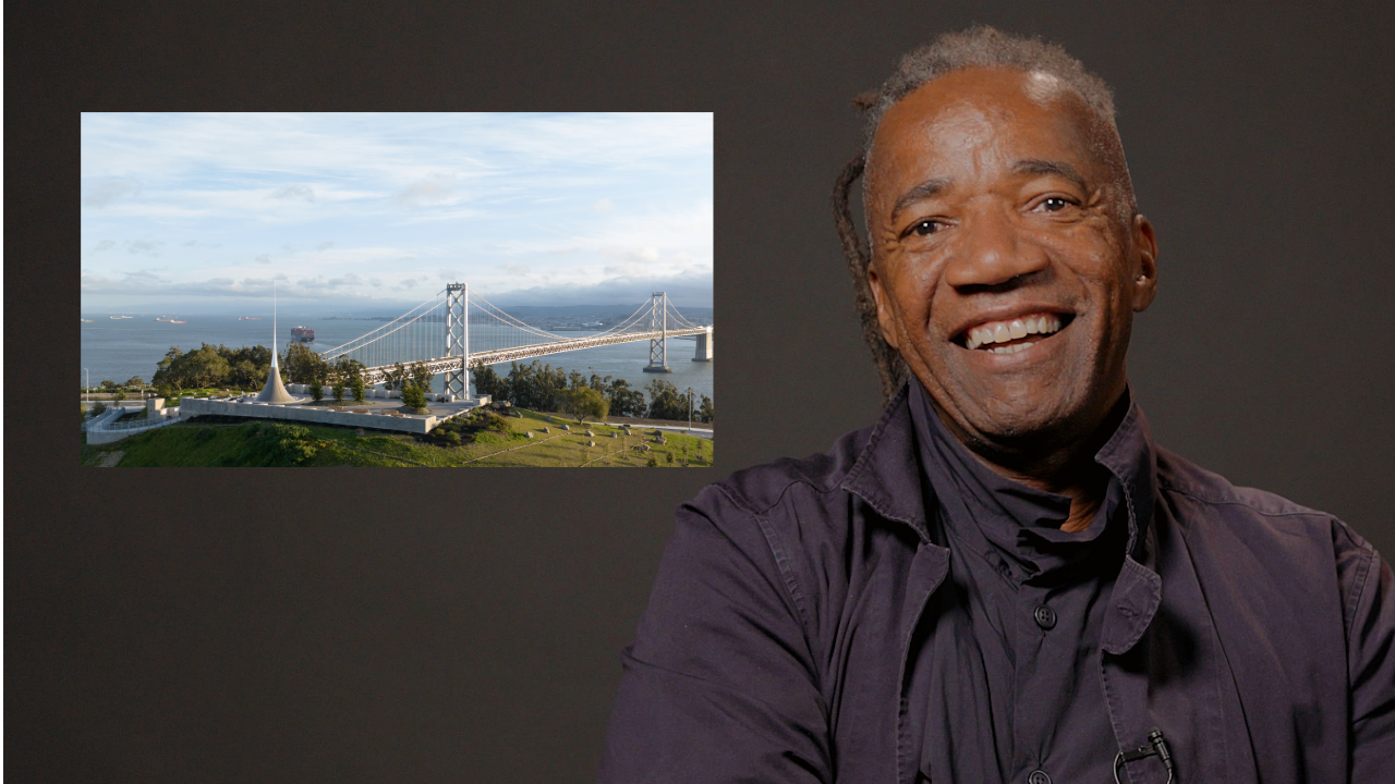 Landscape architect Walter Hood sits, smiling, as he speaks to the camera next to a still photo of a bridge.