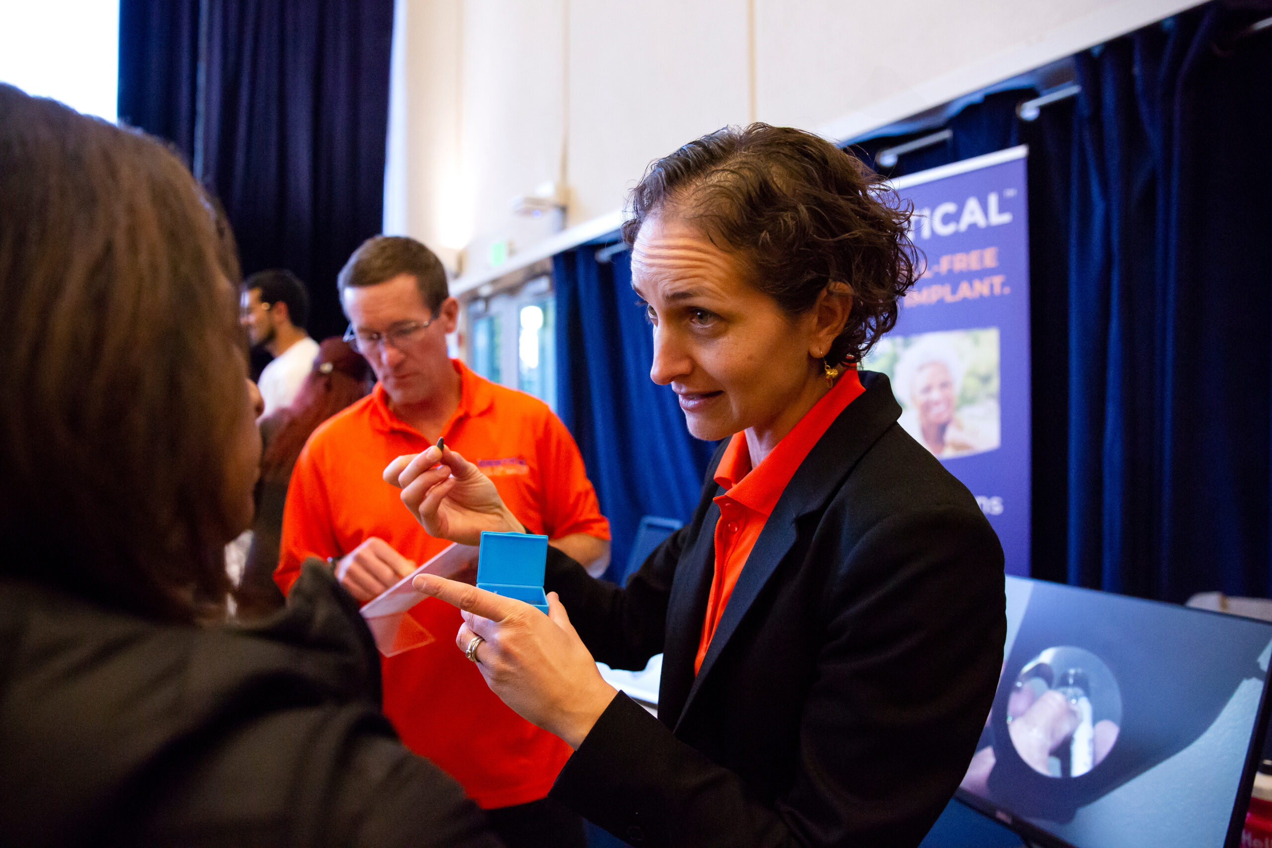 A person during an event for business startups at UC Berkeley demonstrates a dental implant that her company produces.