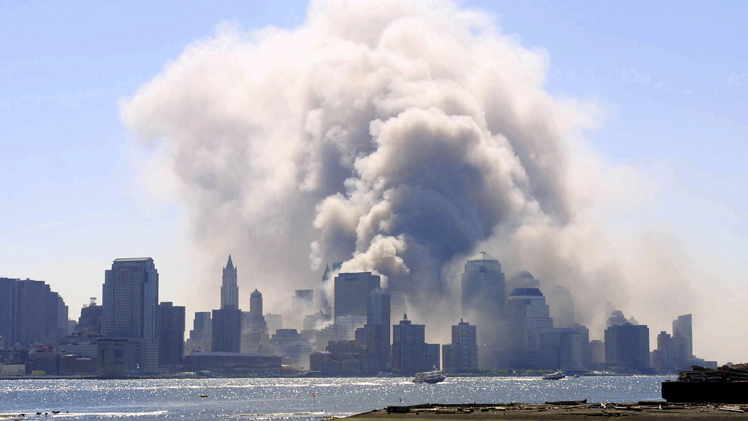 huge plumes of smoke billow into the sky over New York City's buildings after the terrorist attack on 9/11/2001