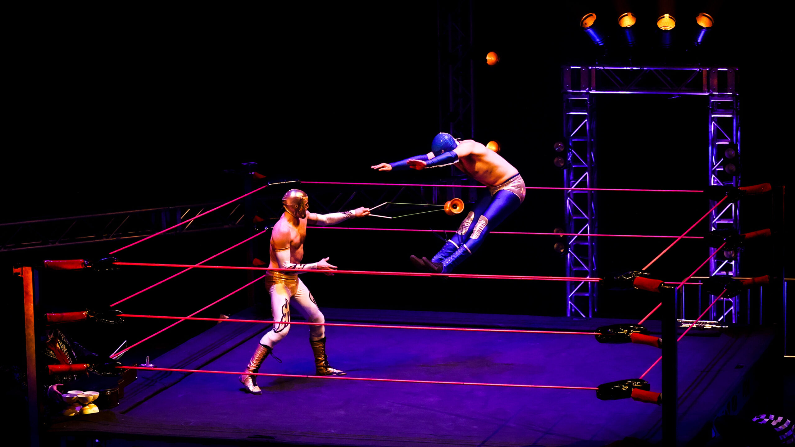 two acrobatic performers dressed as pro wrestlers