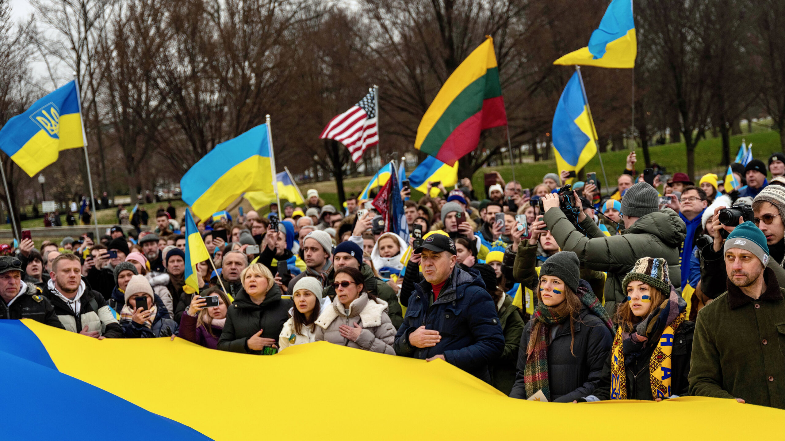 Audience members at a rally in support of Ukraine wave Ukrainian flags and the United States flag