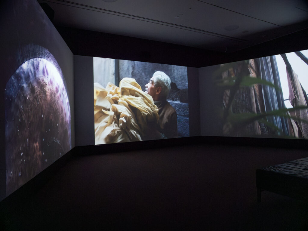 A photo of the screens displaying video work from "“Abounaddara: The Ruins We Carry"