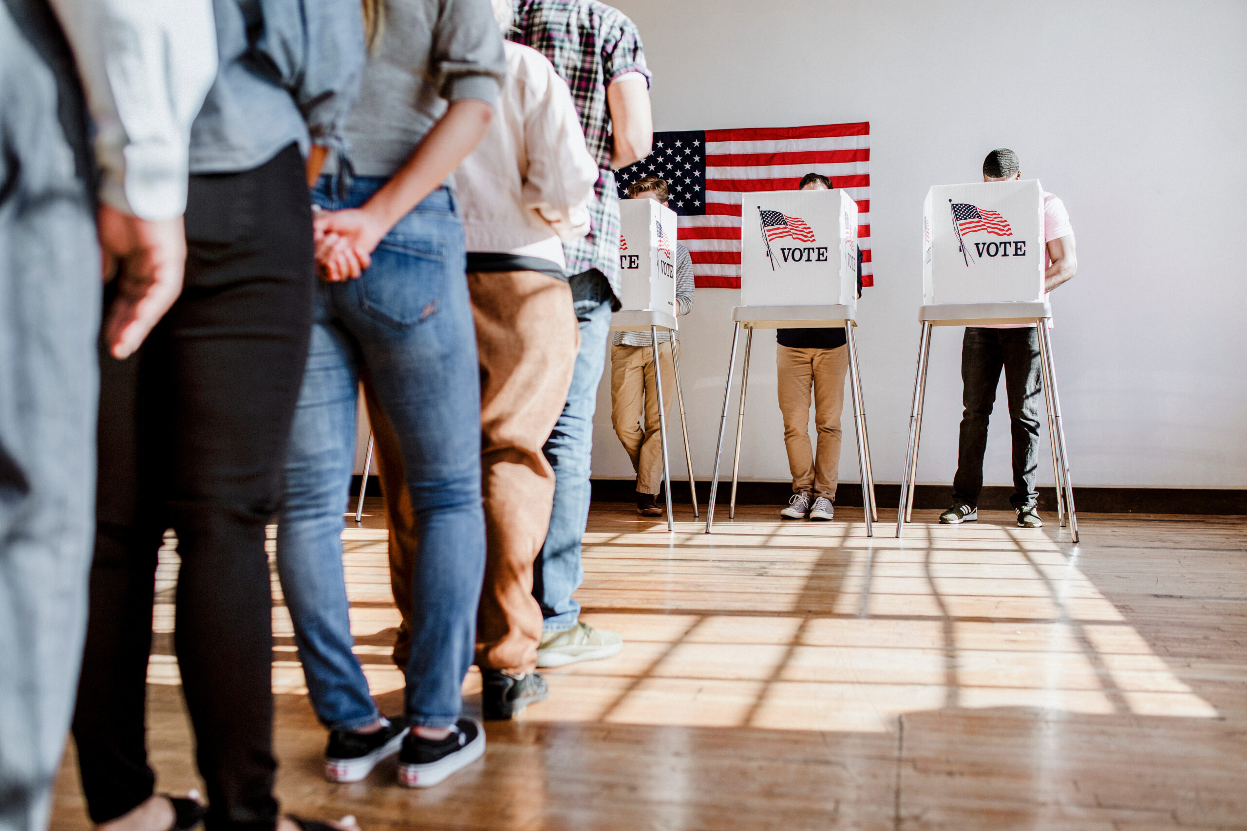 People wait in line to vote in polling booths.