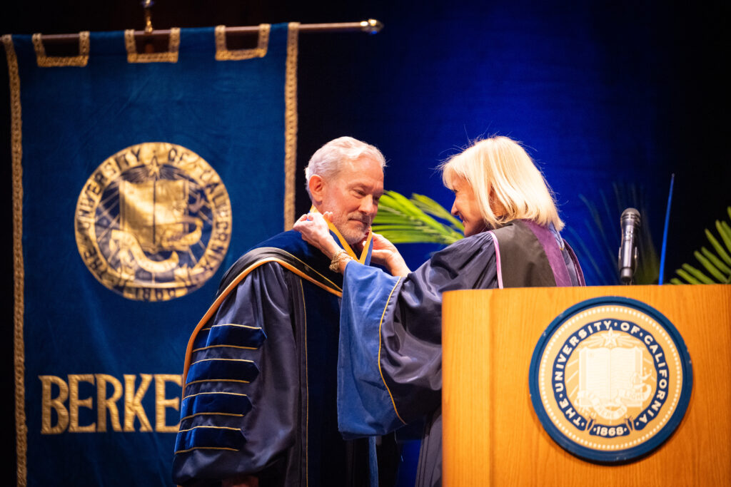 Janet Reilly places a medal around the neck of Rich Lyons