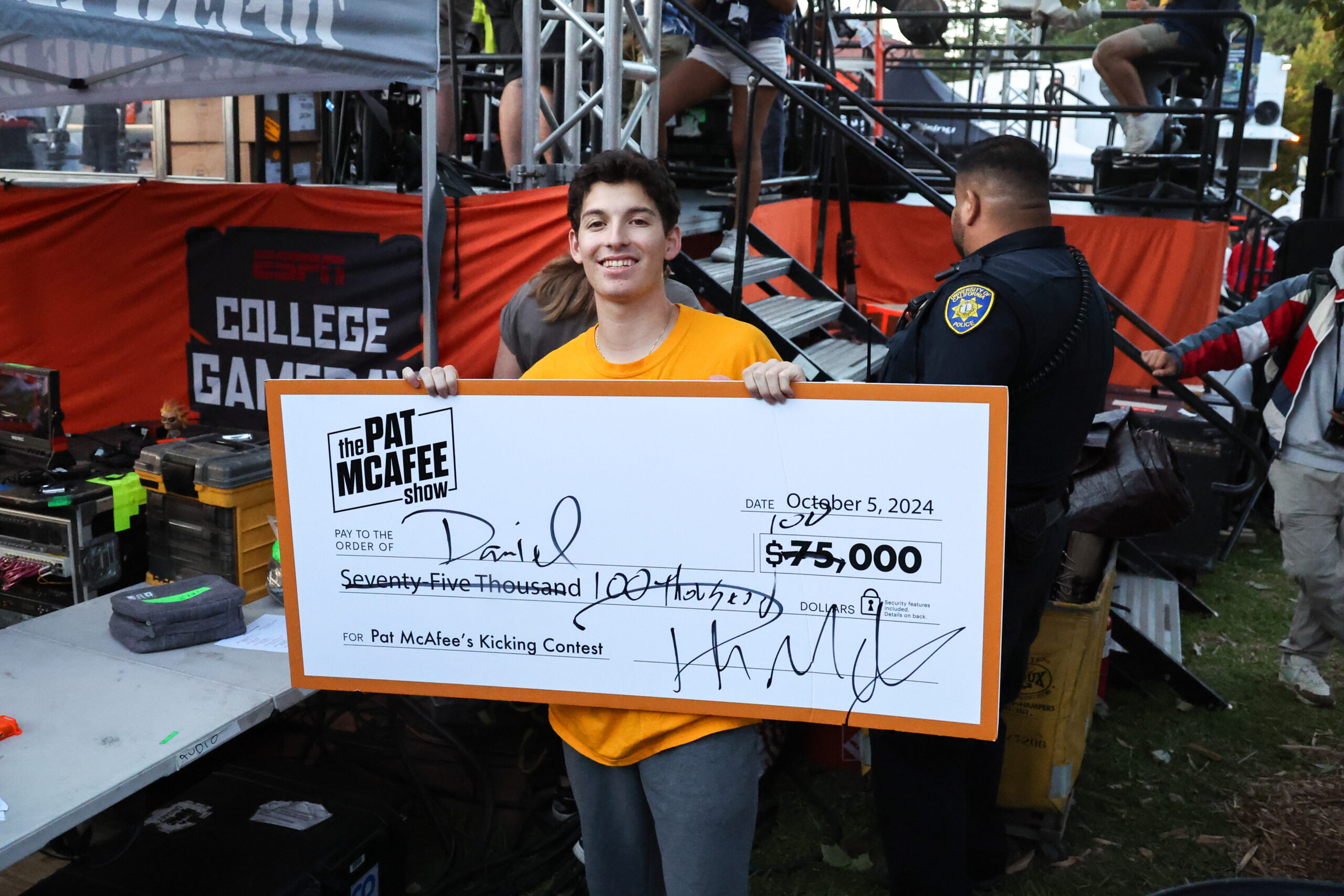 UC Berkeley sophomore Daniel Villaseñor holds a check for $100,000 after winning a field goal contest.