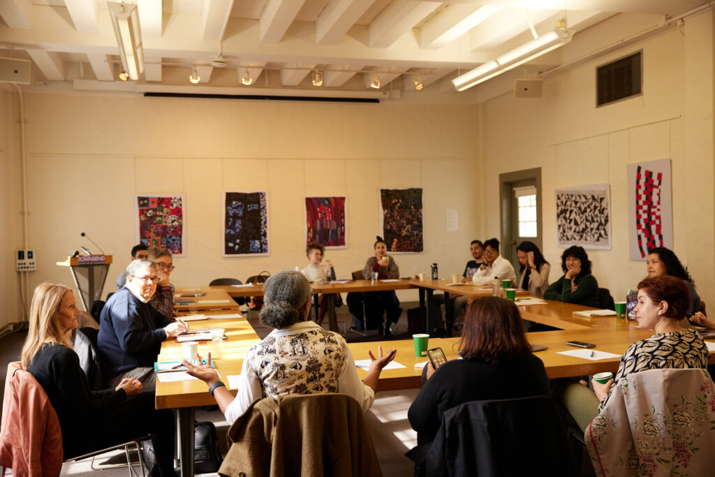 Faculty members sit in the Geballe Room of the Townsend Center for the Humanities, talking abouit how to support new humanities faculty members with resources and mentorship.