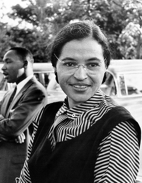 an informal black-and-white portrait of Rosa Parks, the civil rights icon, in 1955. The Rev. Martin Luther King is in the background, to the left.