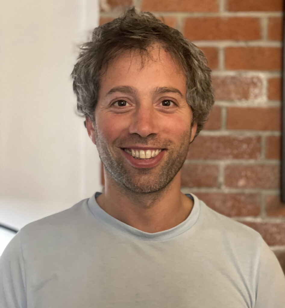 a smiling bearded man in a T-shirt