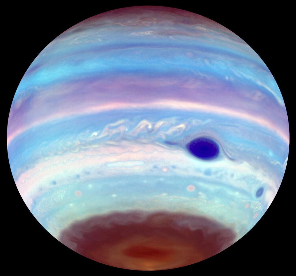 a blue Jupiter with a dark blue spot and a chocolate-brown cap at the bottom