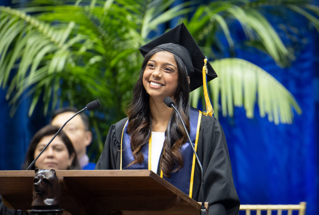 Prisha Bhadra stands smiling at a podium