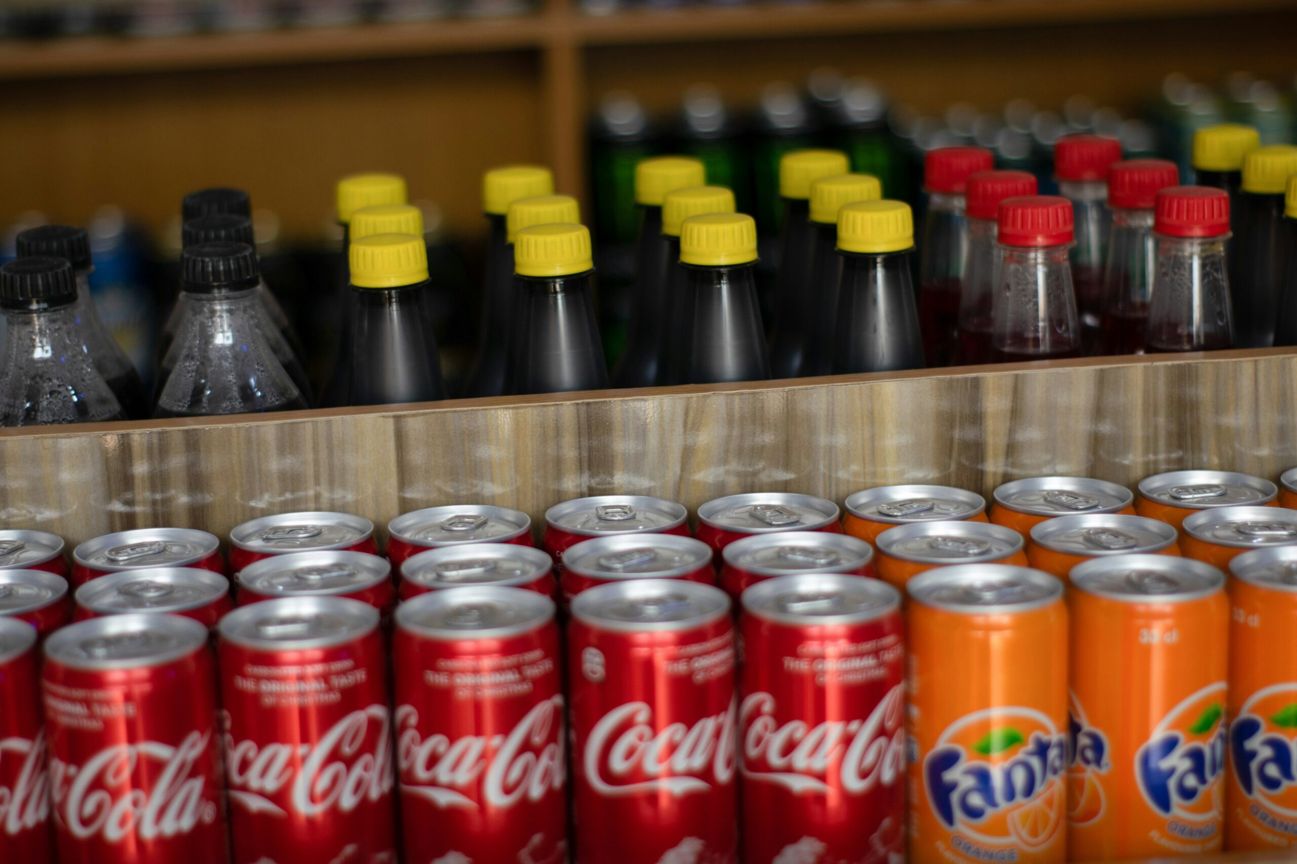 several rows of soda and other sugar-sweetened beverages on a shelf