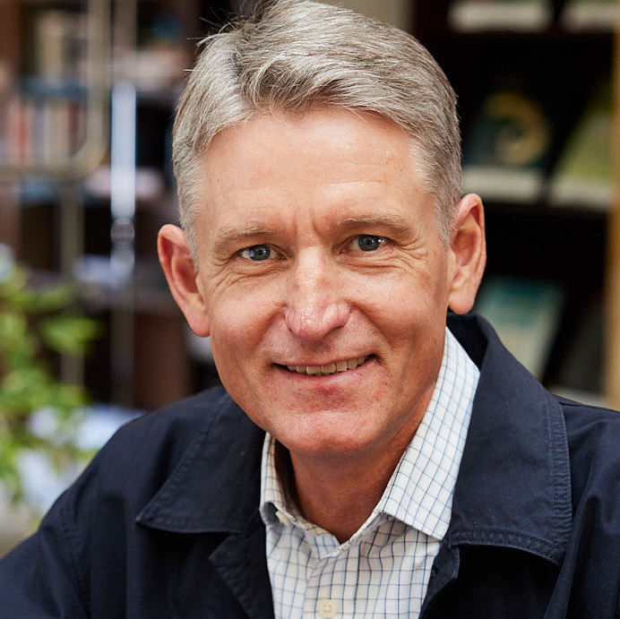 smiling man in office in blue shirt and jacket