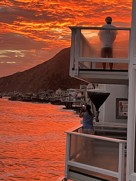 A couple watches the sunset from their home in Malibu. The home burned in the Palisades Fire and was where UC Berkeley staff member David Murray grew up.