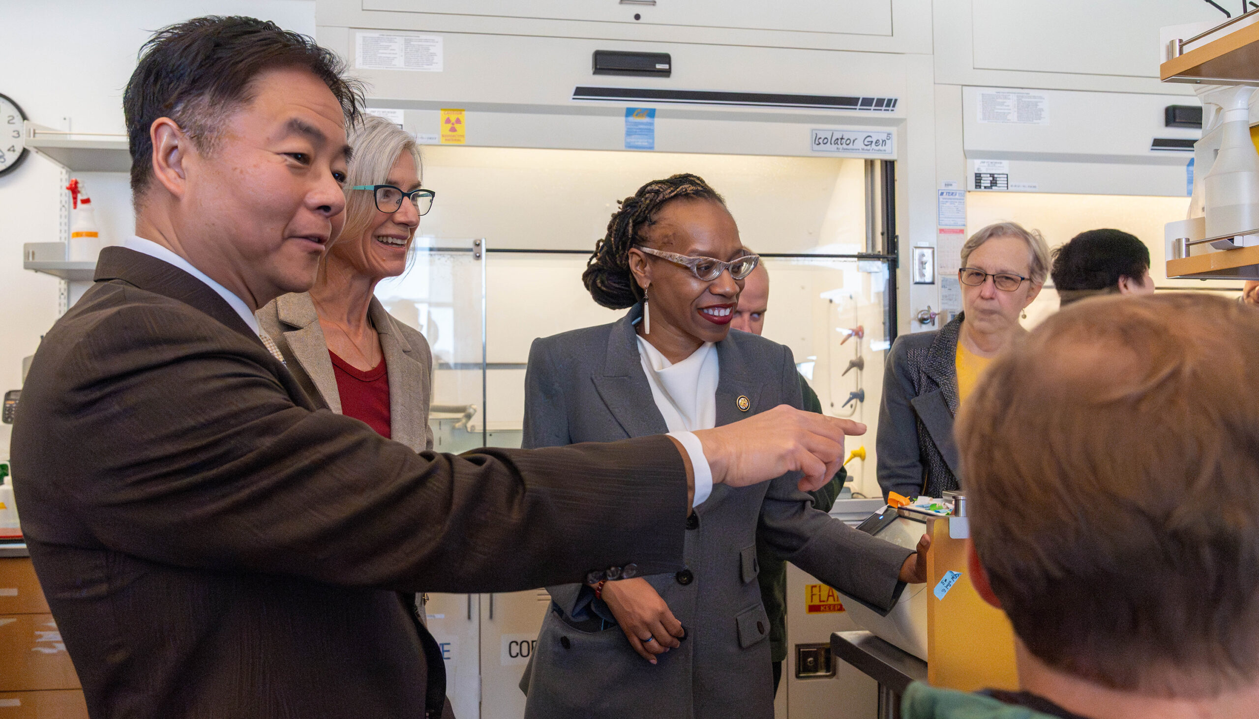 people in a laboratory, one of them pointing toward a computer screen