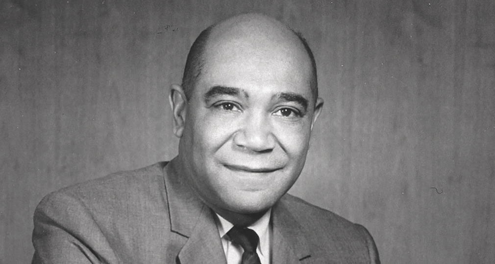 a black-and-white headshot of a man with bushy eyebrows and a gentle.