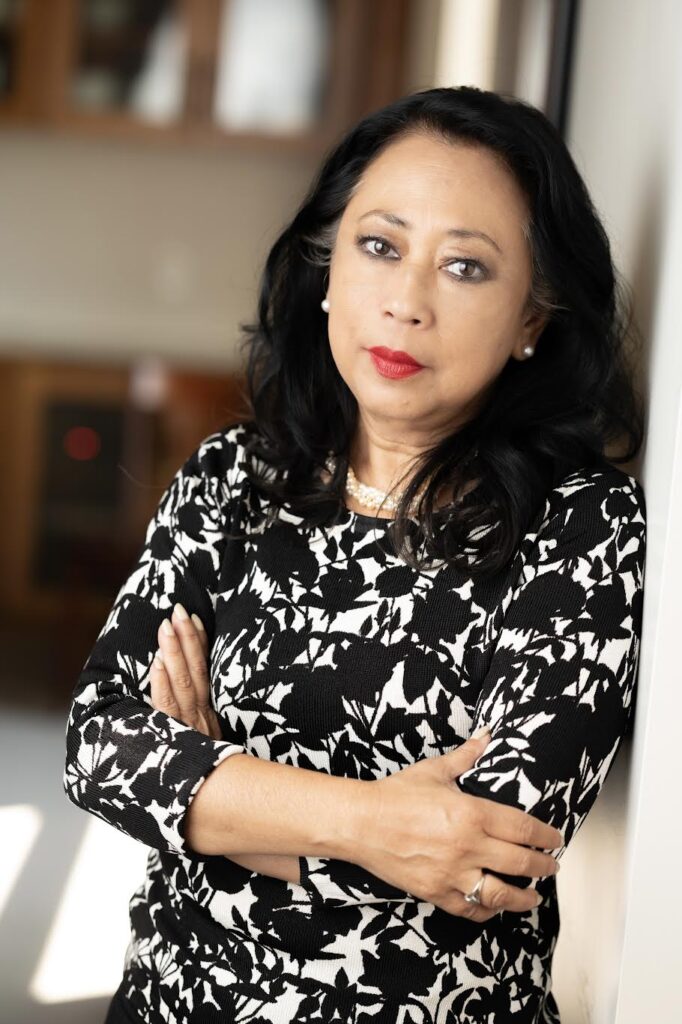 Headshot of Khatharya Um, a Cambodian woman wearing a black-and-white shirt and a string of pearls.