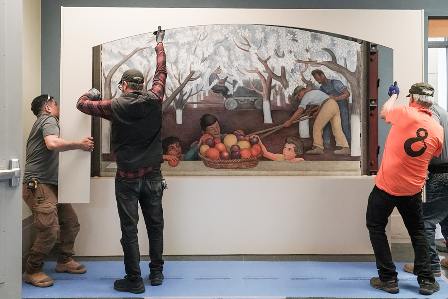 Workers building a stand and case to hold a large Diego Rivera mural at Doe Library.