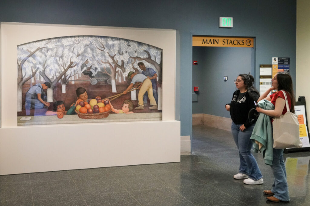 Visitors to Doe Library stop to admire and talk about the Diego Rivera mural installed there on April 30, 2025.