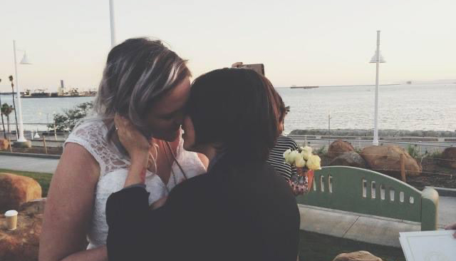 Emily and her then-girlfriend (now wife) Yasmin kiss during their wedding in 2014