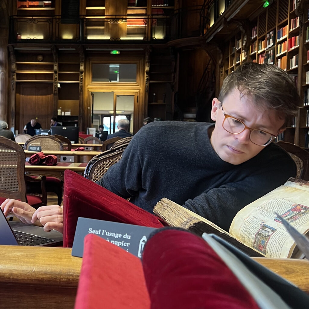 Henry Ravenhall studies medieval manuscripts in a library