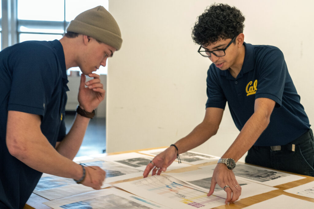 Carlos Quezada, on the right, works with a fellow student during a construction competition. They are evaluating site plans and how each fits into the project schedule.