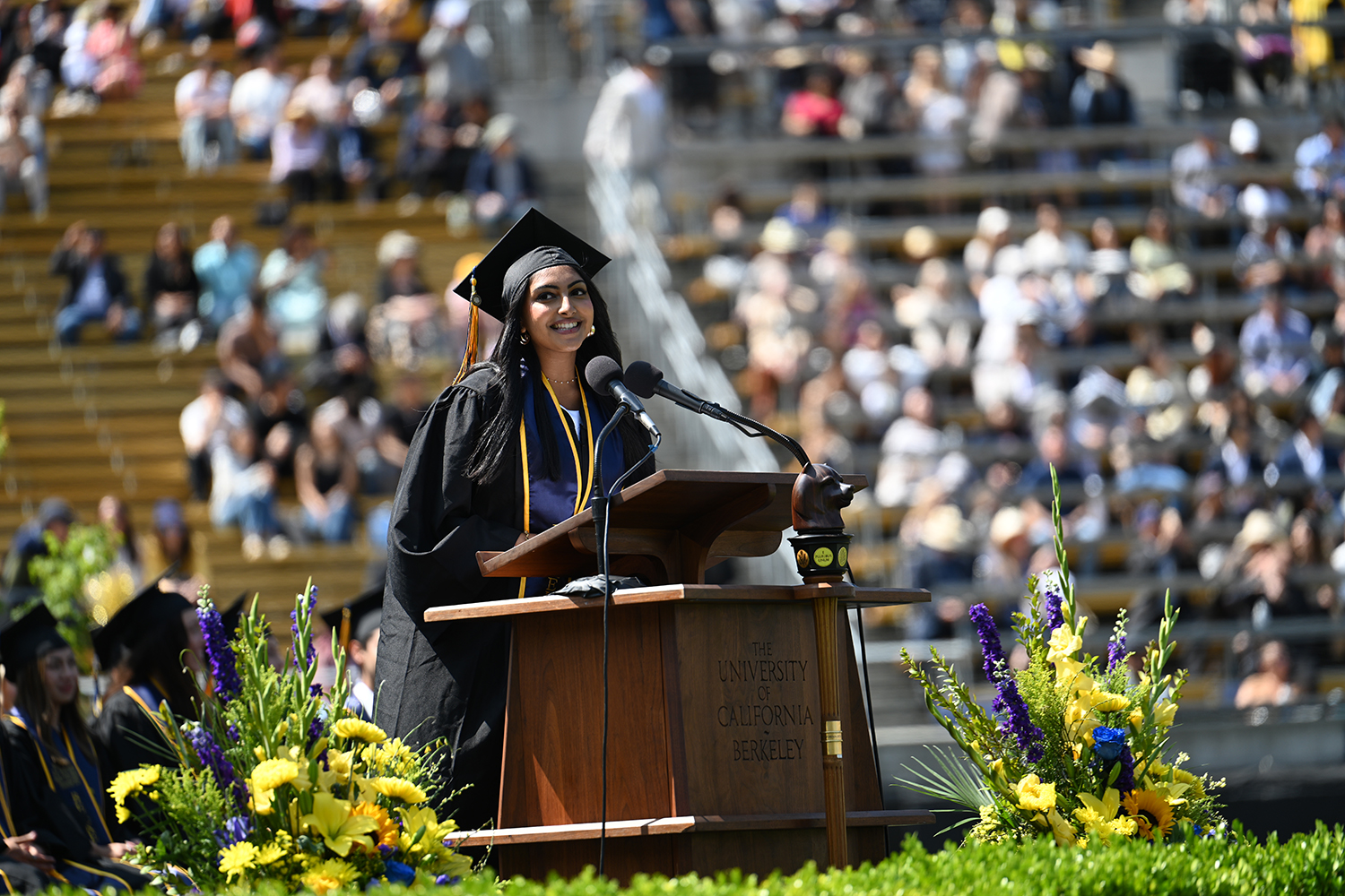 Graduating senior ASUC President Shrinidhi Gopal stands at the podium and gives a speech at the 2025 campuswide commencement.