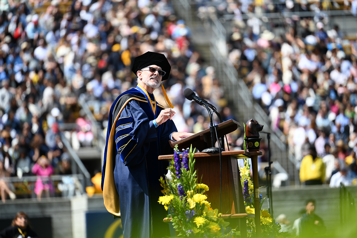 Chancellor Rich Lyons, dressed in regalia, addresses graduates at the 2025 campuswide commencement convocation in California Memorial Stadium.