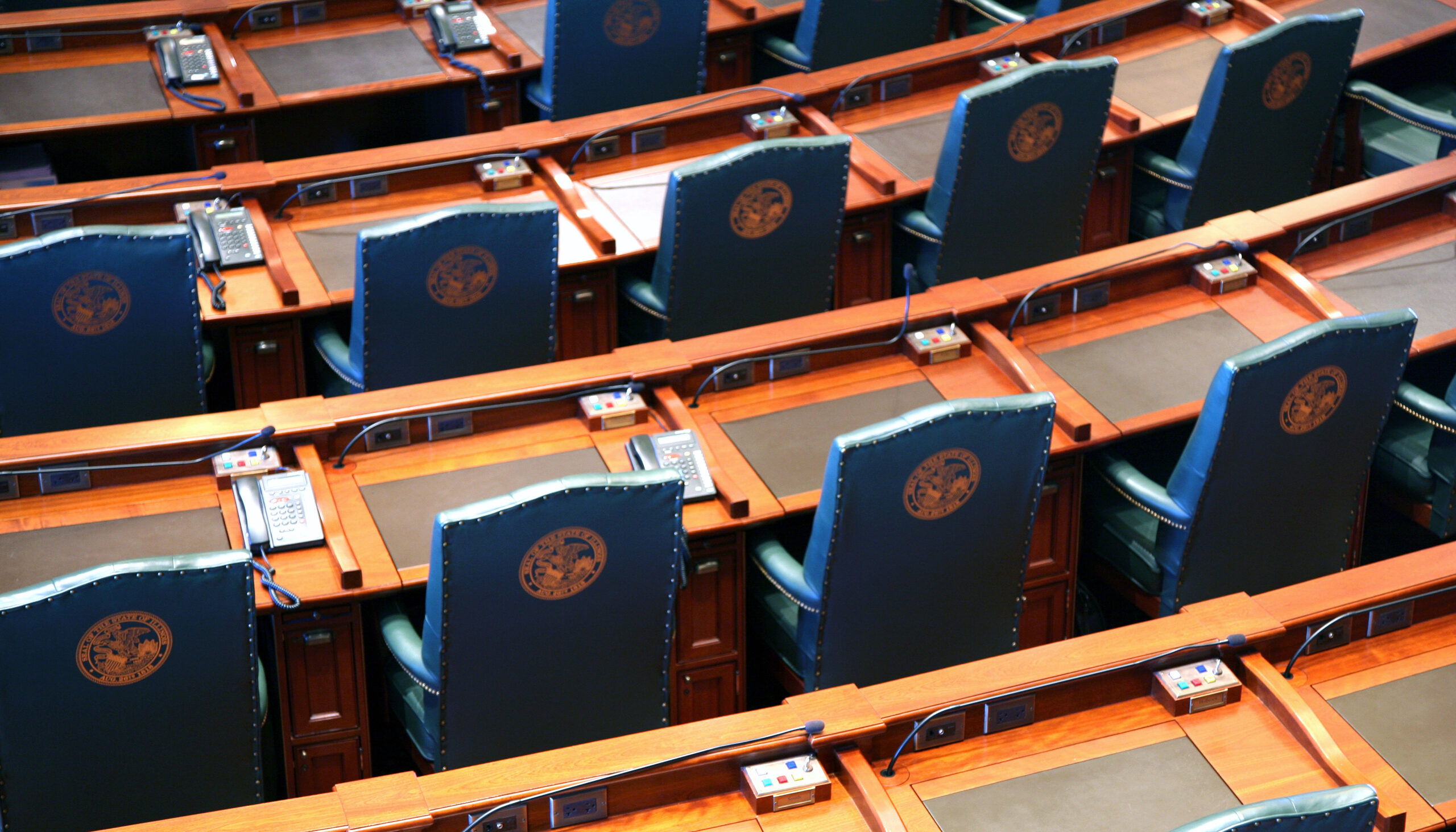 arcing rows of empty chairs in a legislative chamber