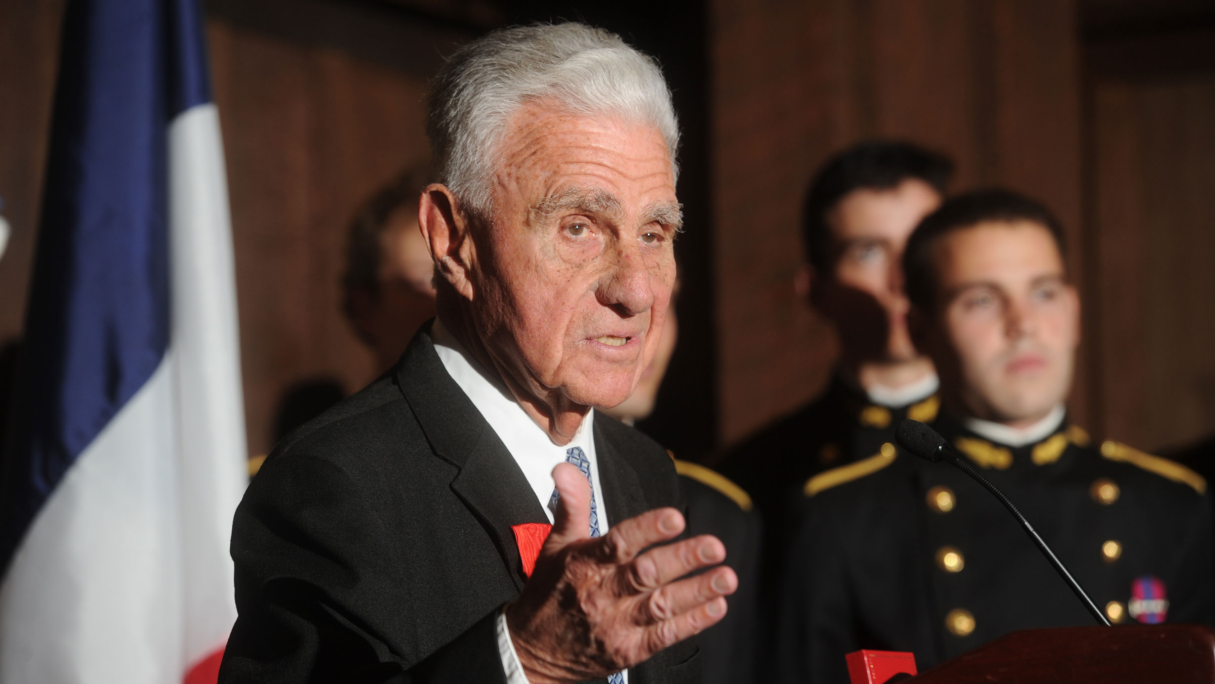 A man gives a speech while standing at a podium.