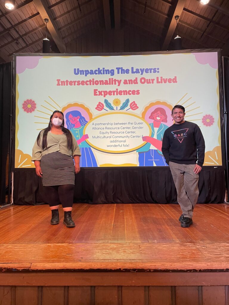 Villegas (left) stands with Vic Hosley-Sánchez, Program Director for the Queer Alliance Resource Center, at a presentation for incoming students.