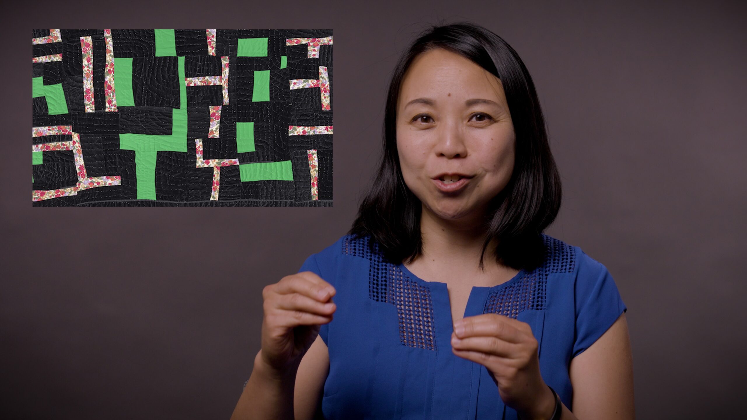 A woman on a gray background speaking with an inset image of a close up of a quilt pattern.