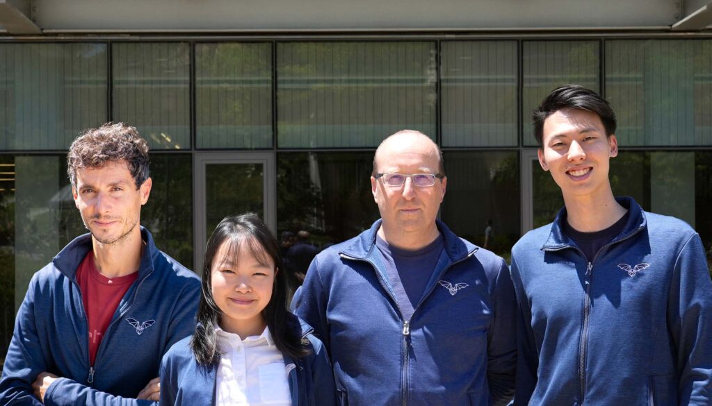 Four people standing in a group.