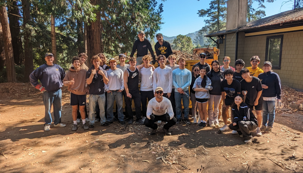 A group of students stands next to a house in the Berkeley Hills.