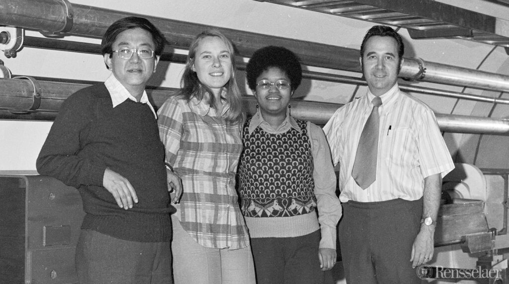 two women and two men standing in front of pipes