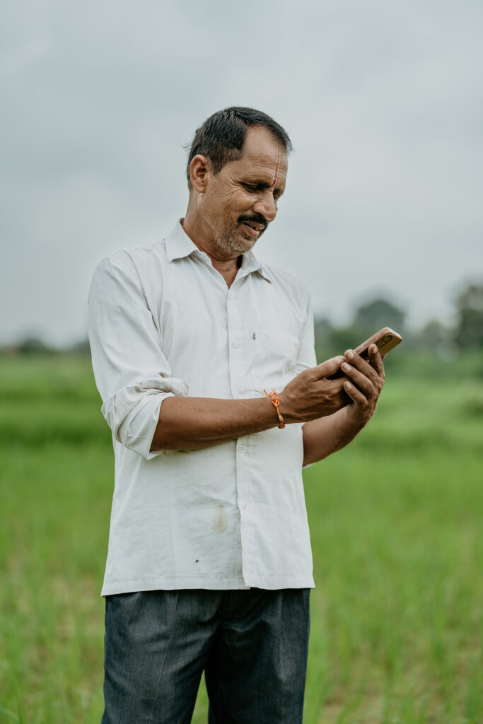 a man in white shirt looking at mobile phone