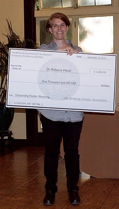 Postdoc holding replica of check