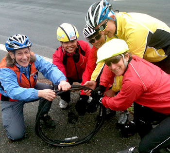 Cal Team members fix a flat on a training ride.