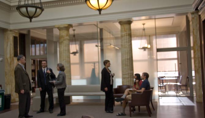 Second-floor renovation features gradient-opacity glass partitions, to create office space while preserving a sense of the room's original dimensions.