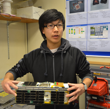 Student Jerry Kim with CINEMA nanosatellite.